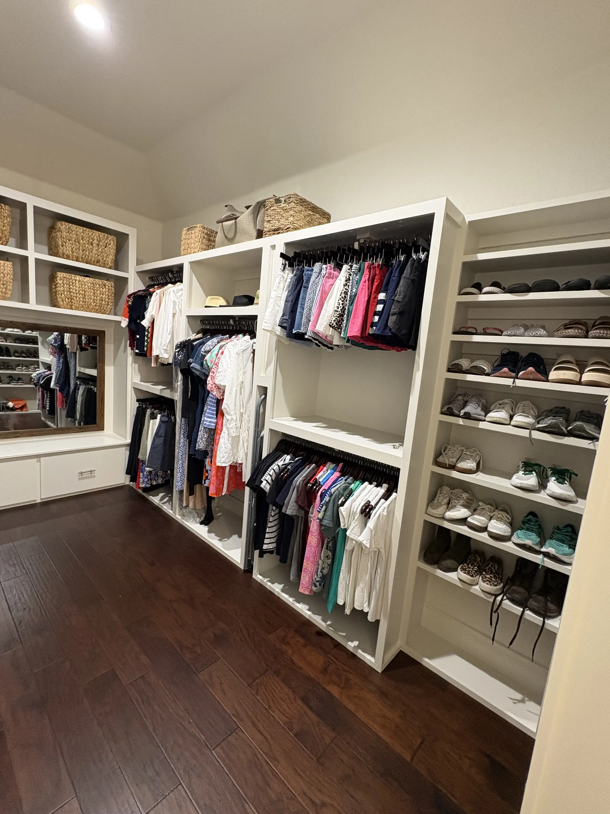 Finished walk in closet with hanging sections, drawers and shoe storage built to the room's dimensions