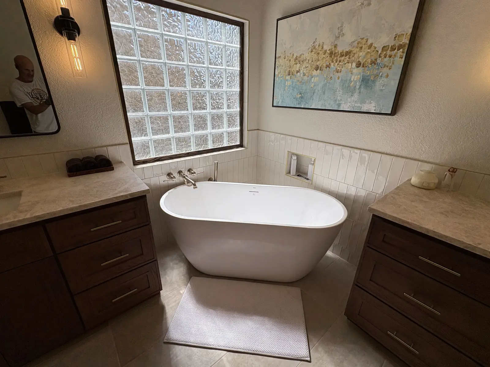 Primary suite bathroom with a freestanding tub and stacked white tile