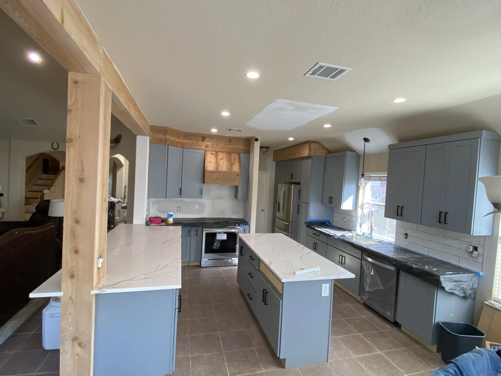 Schertz kitchen with blue grey cabinetry and cedar ceiling beams
